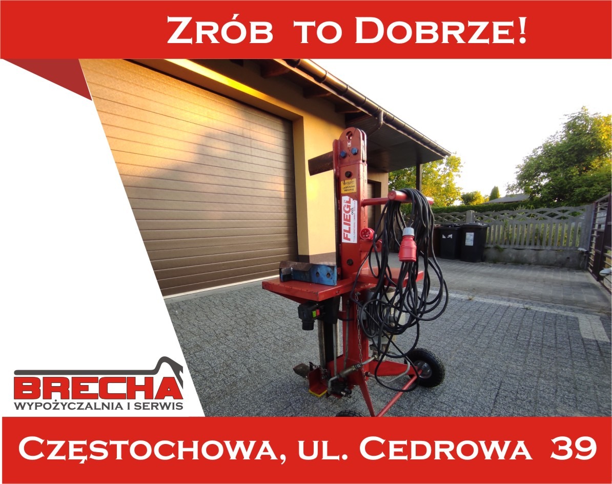 Czerwona, pionowa łuparka do drewna marki Fliegl, z czarnym kablem, na tle brązowej bramy garażowej i kostki brukowej, z widocznym logo firmy Brecha.