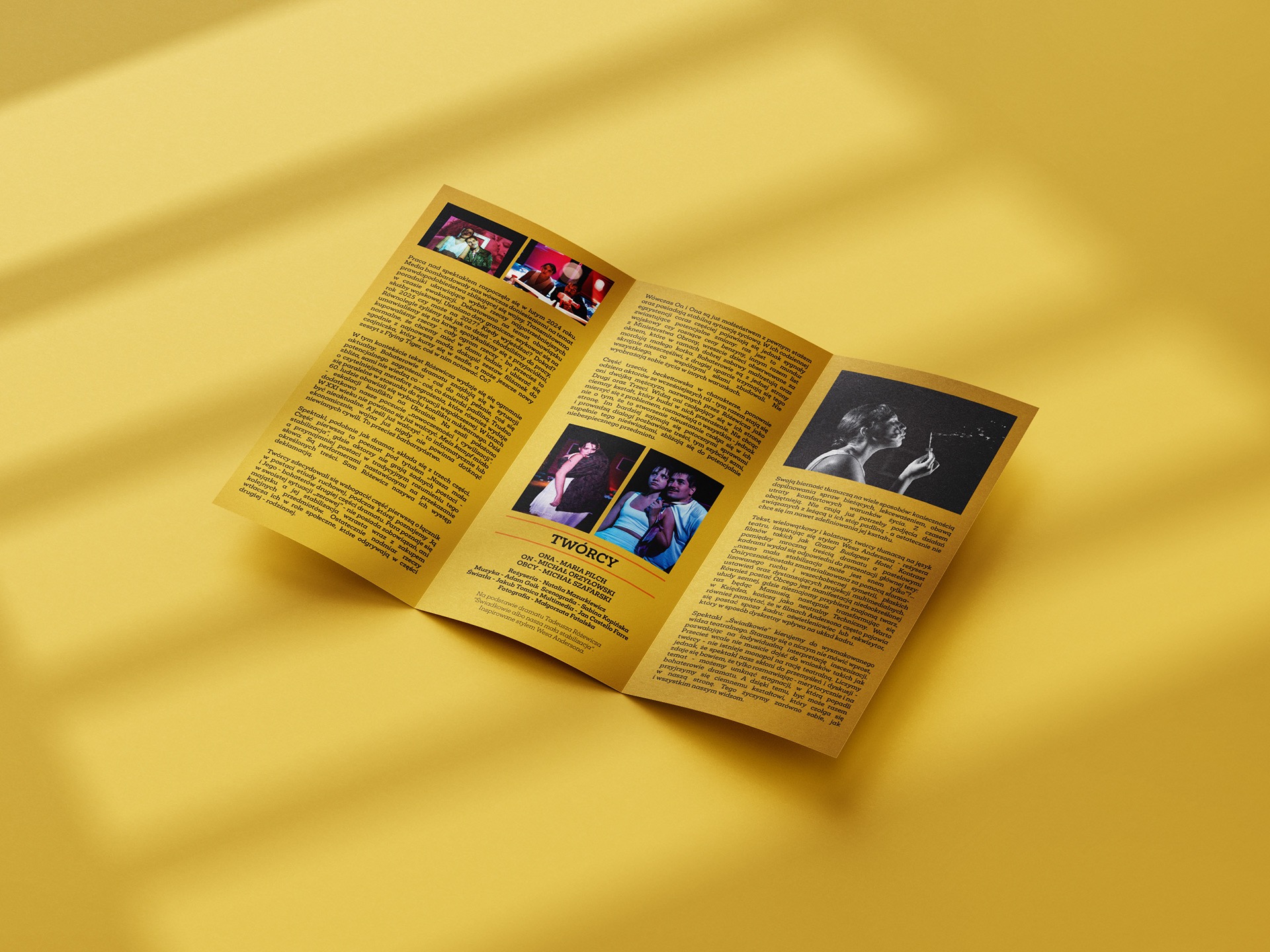Ułożona pod kątem, rozłożona ulotka teatralna z tekstem i zdjęciami, leżąca na żółtym tle. Widoczne trzy kolumny tekstu, zdjęcia aktorów i twórców spektaklu.