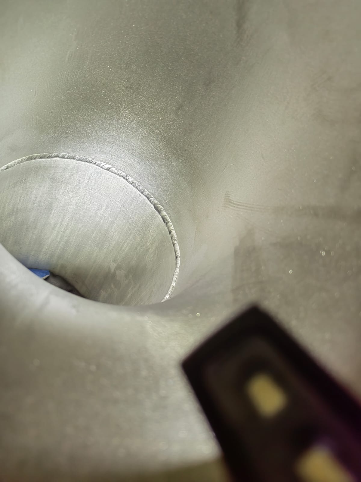 Wnętrze metalowej rury w Gdańsku, widoczny spaw na obwodzie, uchwycony pod nietypowym kątem z użyciem dodatkowego oświetlenia.