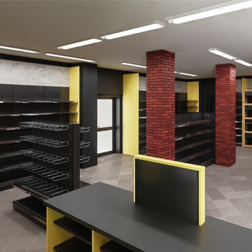 Wnętrze sklepu z pustymi, czarnymi regałami z żółtymi akcentami, oświetlone jarzeniówkami, z kolumnami obłożonymi czerwoną cegłą i szarą podłogą z płytek.