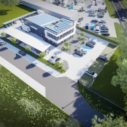 Wizualizacja z lotu ptaka nowoczesnego budynku biurowego z panelami słonecznymi, parkingiem, zielenią i drogą dojazdową. Budynek o nazwie KOS-TALA.