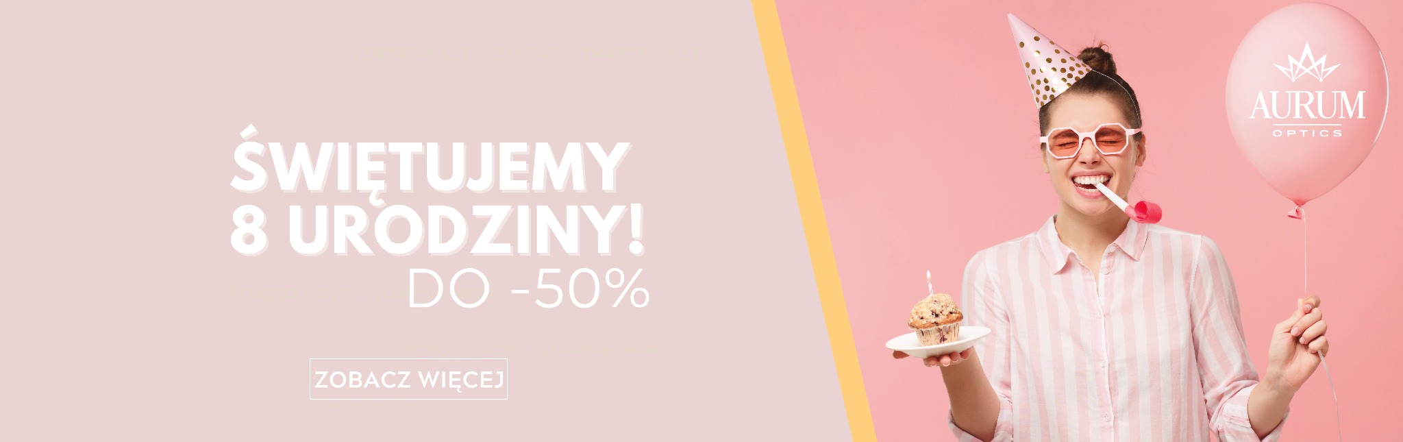 Uśmiechnięta kobieta w różowych okularach i czapeczce urodzinowej dmucha w gwizdek trzymając babeczkę ze świeczką i balon z logo Aurum Optics na różowym tle, promocja 8 urodzin.