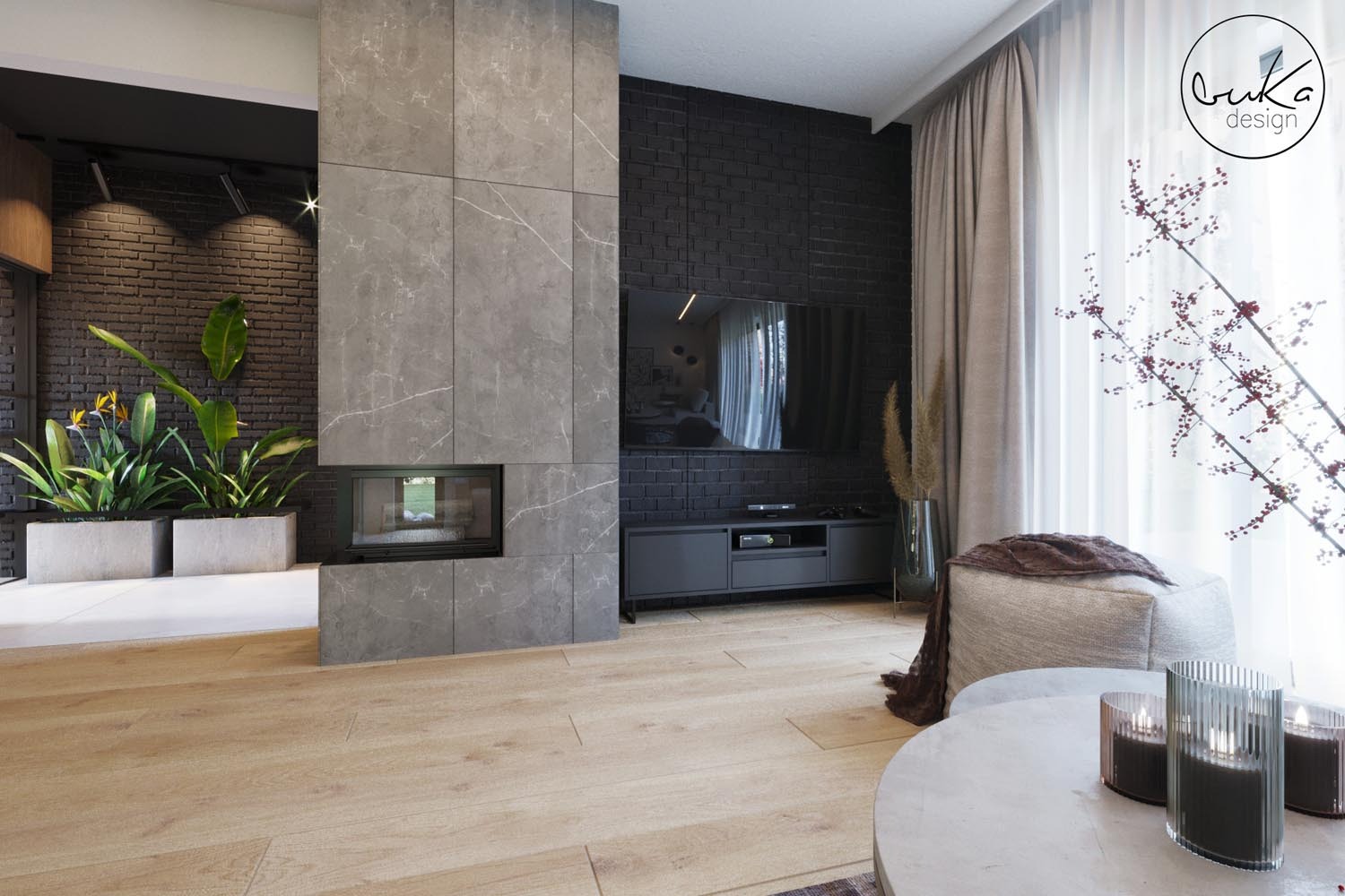 Salon z kominkiem obudowanym płytami imitującymi marmur, czarną ścianą z cegły, drewnianą podłogą i roślinami w betonowych donicach, widoczne także detale dekoracyjne i logo firmy.