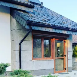 Elewacja budynku jednorodzinnego z wykonaniem imitacji płyt betonowych tynkiem dekoracyjnym