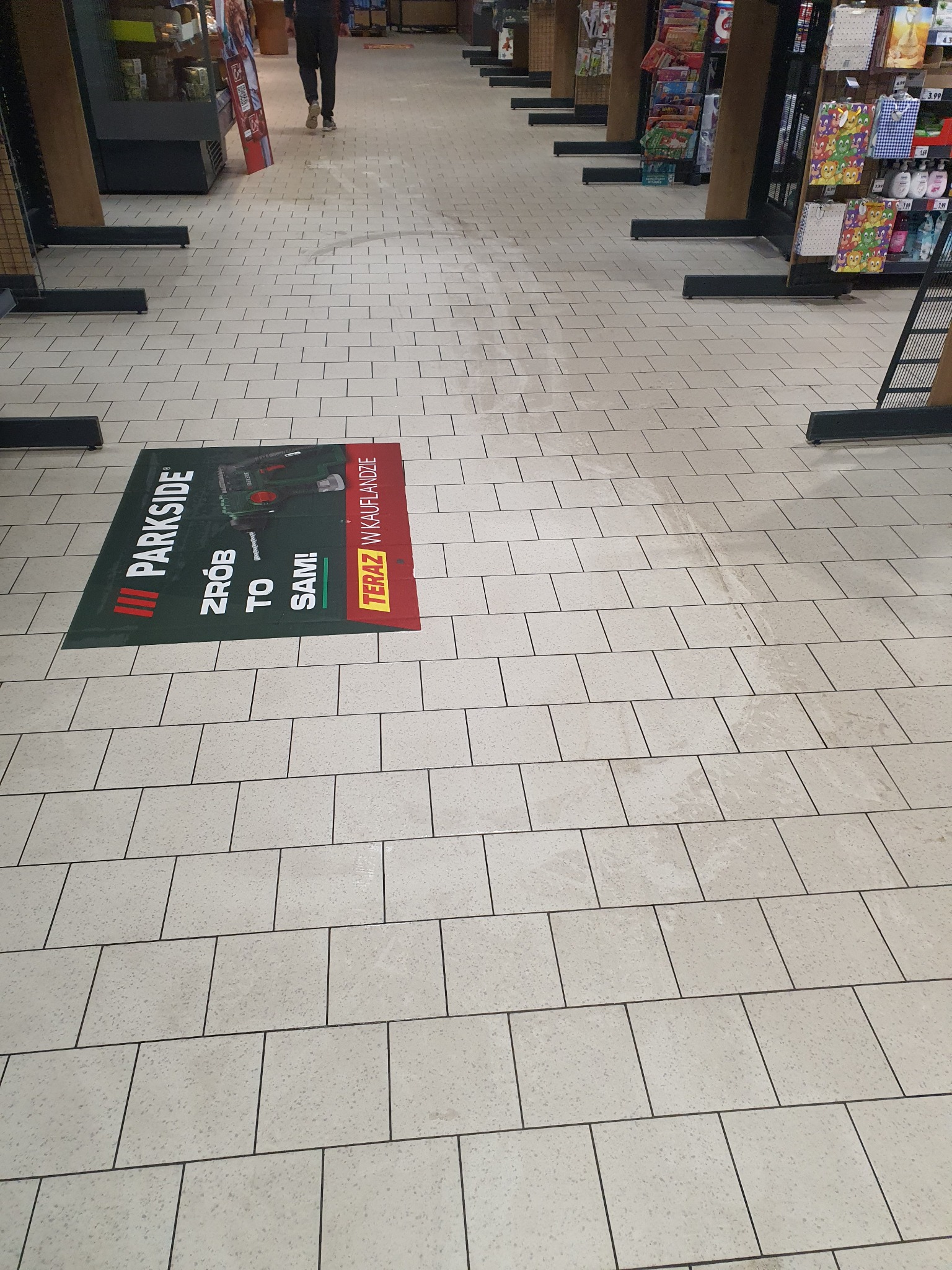 Płytki podłogowe w sklepie z naklejką reklamową marki Parkside z hasłem 'Zrób to sam!'