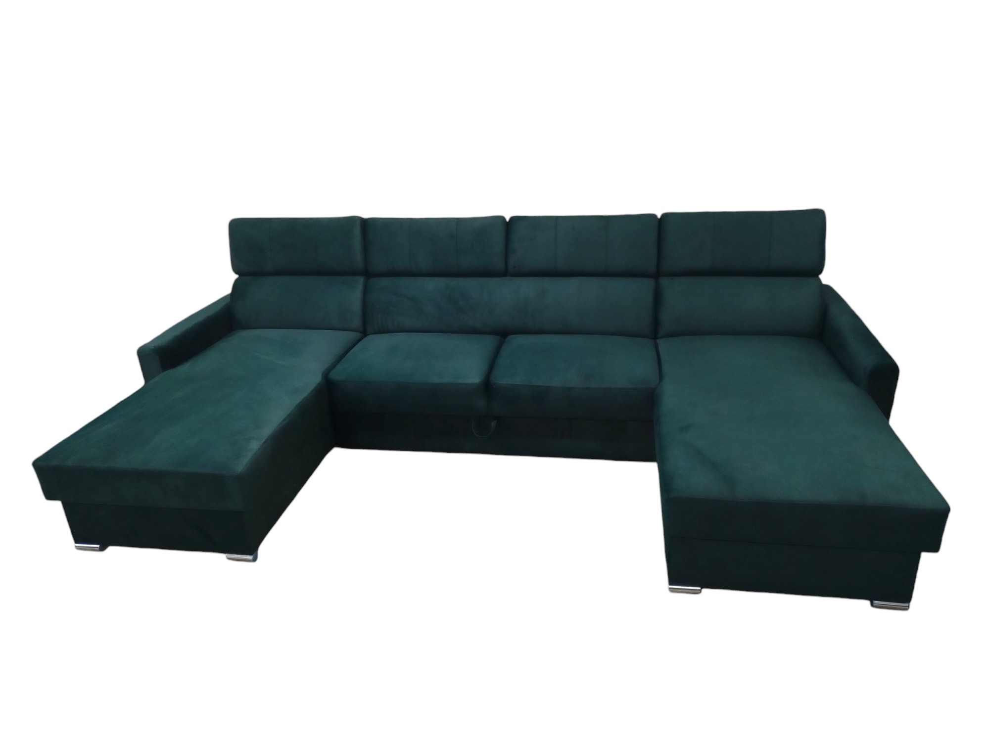Nowoczesny, rozłożony narożnik tapicerowany ciemnozielonym welurem, z widocznym schowkiem pod siedziskiem, na niskich, metalowych nóżkach.