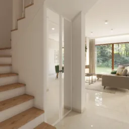 Jasne wnętrze domu z drewnianymi schodami, przeszklonymi drzwiami i widokiem na salon z beżową sofą i dużym oknem na ogród.