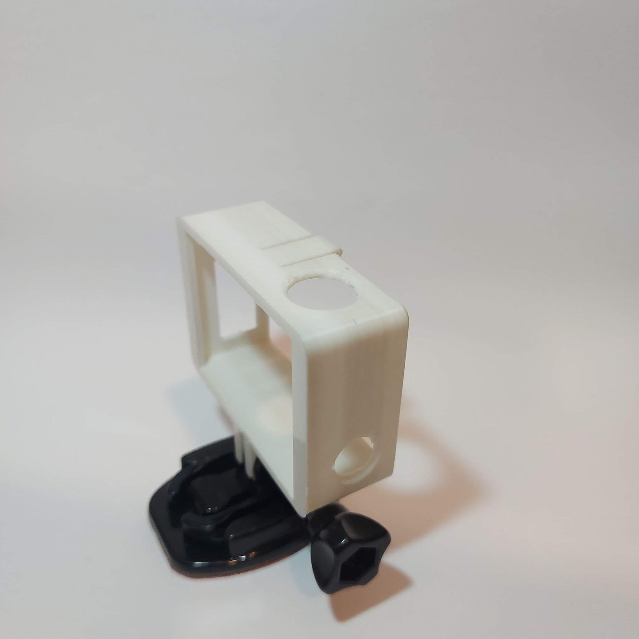 Biała obudowa ochronna do kamery sportowej z czarnym mocowaniem na przyssawkę i śrubą, na jednolitym tle.