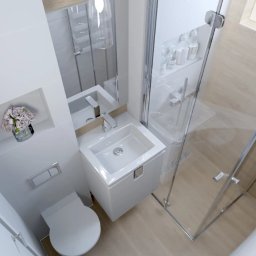 Amable - Wnętrze nowoczesnej łazienki z kabiną prysznicową, umywalką i toaletą. Minimalistyczny design, jasne kolory, kwiaty w niszy. Widok z góry.