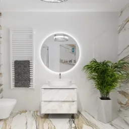 Elegancka łazienka z marmurowymi płytkami, okrągłym lustrem z podświetleniem LED i rośliną doniczkową obok okna z żaluzjami. Nowoczesny design z białymi elementami.