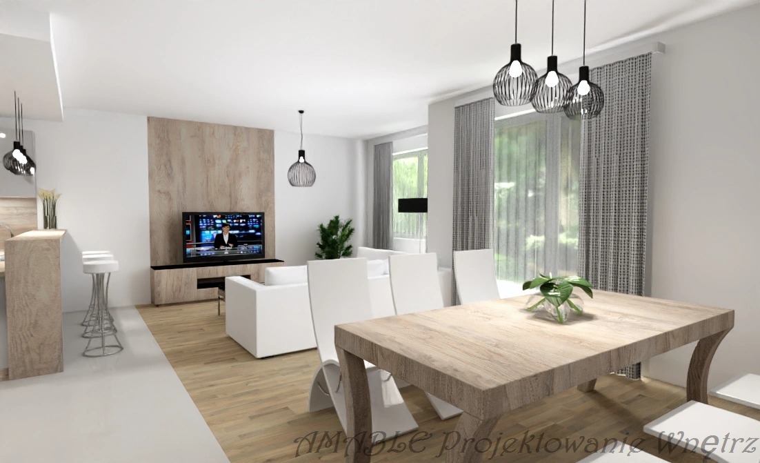 Jasne wnętrze z drewnianym stołem jadalnym, białymi krzesłami i minimalistycznym oświetleniem. W tle salon z telewizorem i roślinami. Projekt z dbałością o detale.