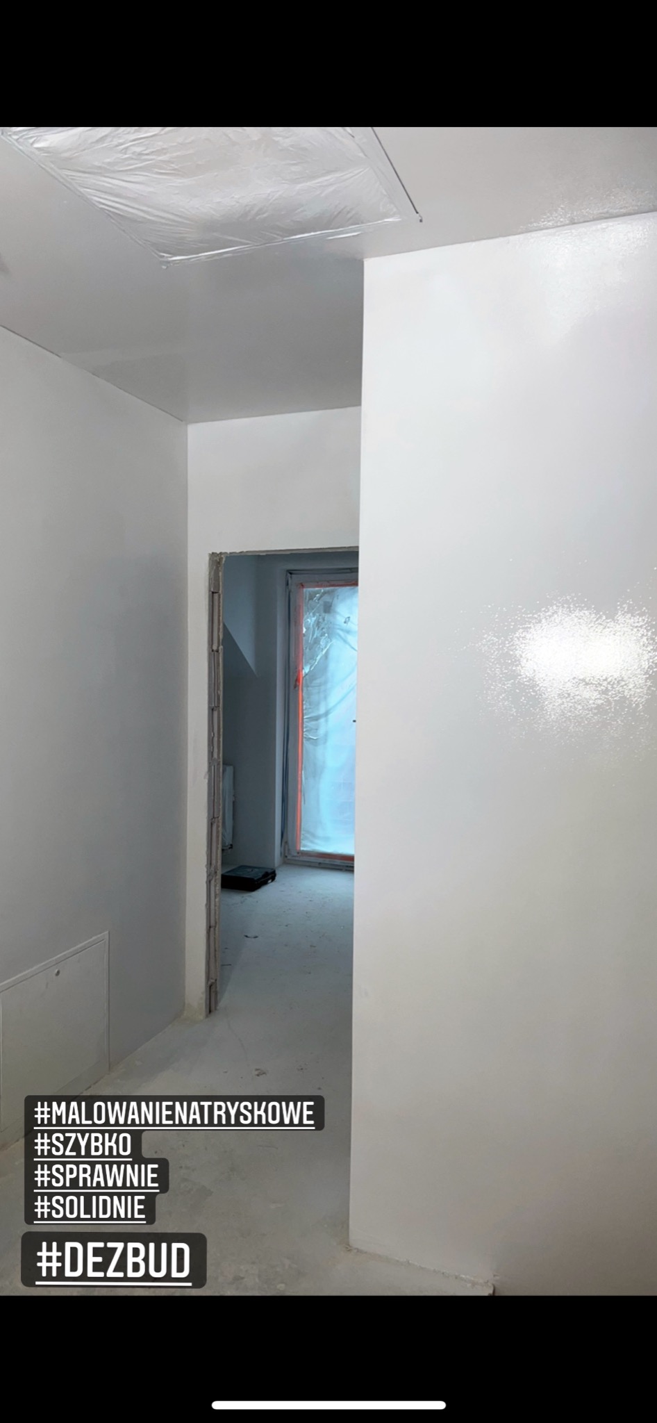 Świeżo pomalowane na biało wnętrze z widocznymi śladami po natryskowym malowaniu, zabezpieczone folią okno w tle.