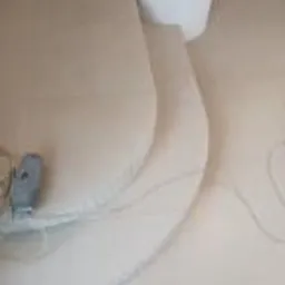 Przygotowanie do położenia gładzi na ścianie: widoczne zarysowane linie, szpachla i wiadro, etap prac wykończeniowych w pomieszczeniu.