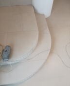 Przygotowanie do położenia gładzi na ścianie: widoczne zarysowane linie, szpachla i wiadro, etap prac wykończeniowych w pomieszczeniu.