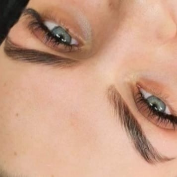 Zbliżenie na kobiece oczy z wyraźnie podkreślonymi, ciemnymi brwiami po zabiegu stylizacji, widoczne drobne włoski i naturalny kształt.