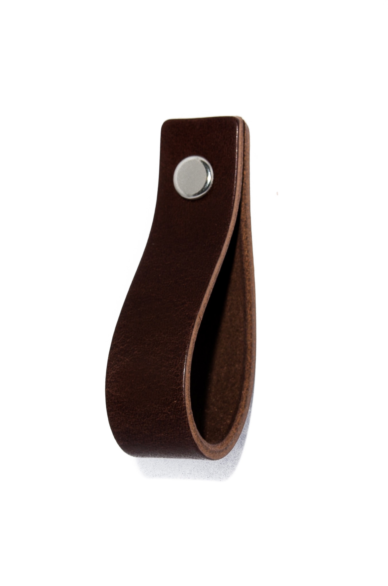 Brązowy uchwyt meblowy ze skóry, przymocowany srebrnym nitem, na białym tle.
