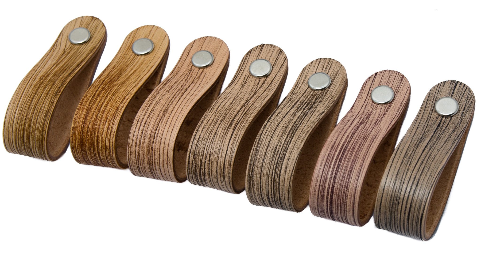 Siedem skórzanych uchwytów meblowych w odcieniach brązu, przymocowanych metalowymi nitami, ułożonych rzędem na białym tle.