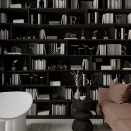 Home by M Martyna Matuszak - Ciemna biblioteczka z książkami i dekoracjami, sofa w odcieniach różu, okrągłe lustro i designerska lampa, minimalistyczne krzesło i roślina doniczkowa, stonowana kolorystyka