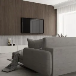 Nowoczesny salon z szarą sofą, drewnianą ścianą TV i dekoracyjną figurką na białej szafce RTV.