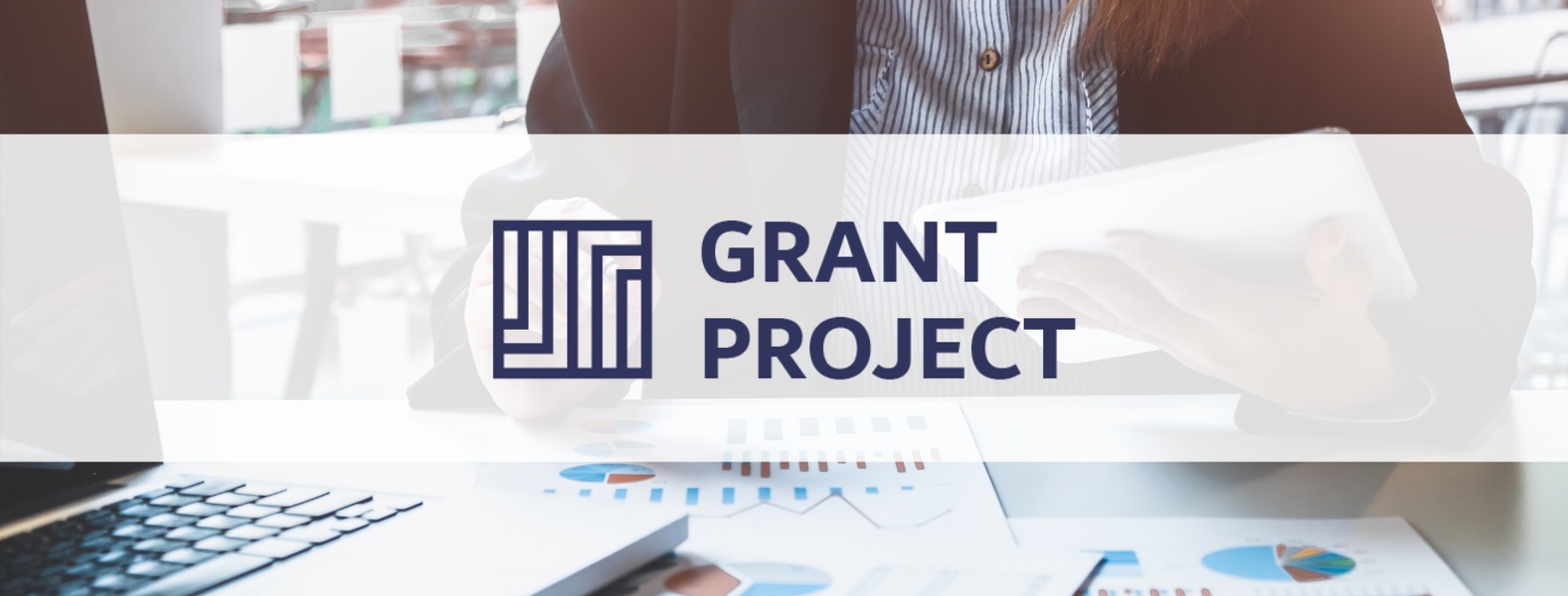 Kobieta w koszuli w paski trzyma tablet nad stołem z laptopem i wykresami kołowymi, logo Grant Project na pierwszym planie.
