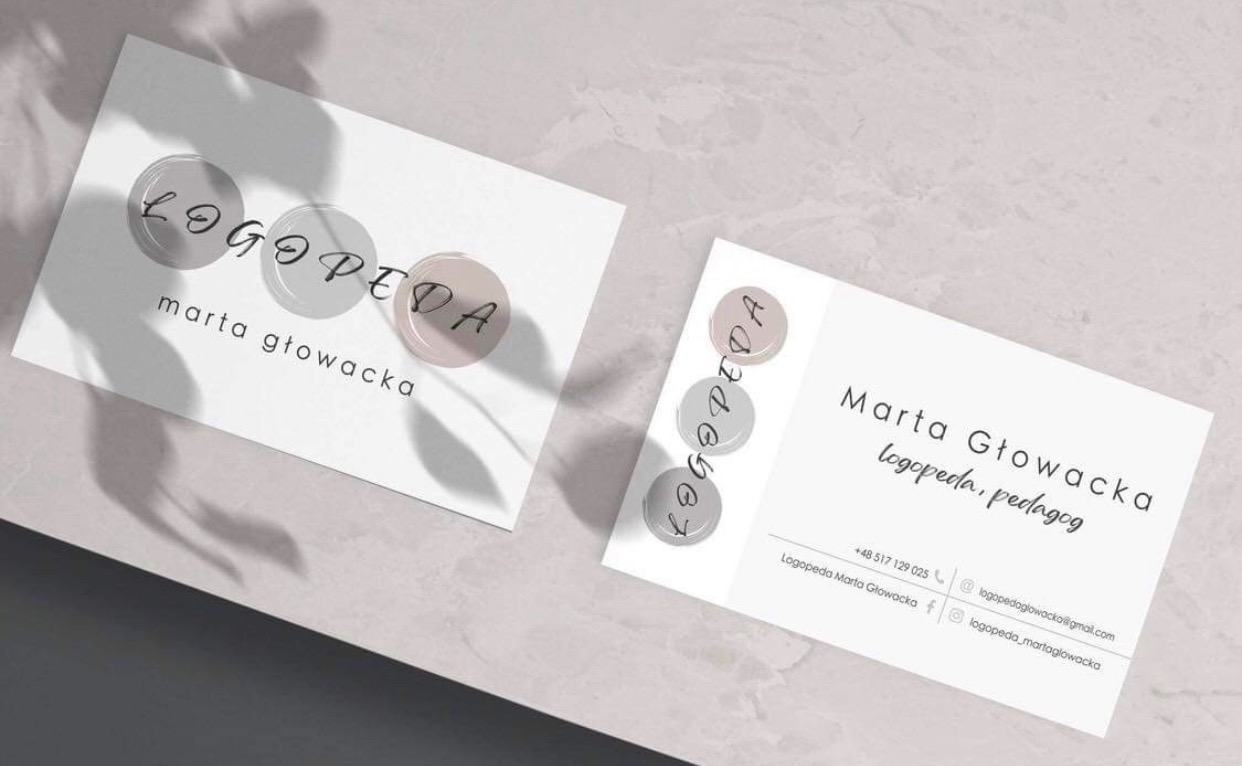 Dwie minimalistyczne wizytówki logopedy Marty Głowackiej z logo w postaci trzech kół w odcieniach szarości i beżu, leżące na jasnym tle z cieniem gałęzi.