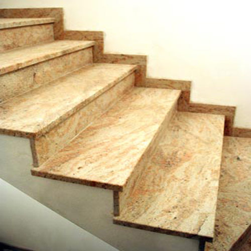 Schody wykończone płytami z polerowanego granitu o ciepłym, beżowo-różowym odcieniu z wyraźnym, falistym wzorem. Stopnie i podstopnice idealnie dopasowane, tworzą eleganckie przejście.