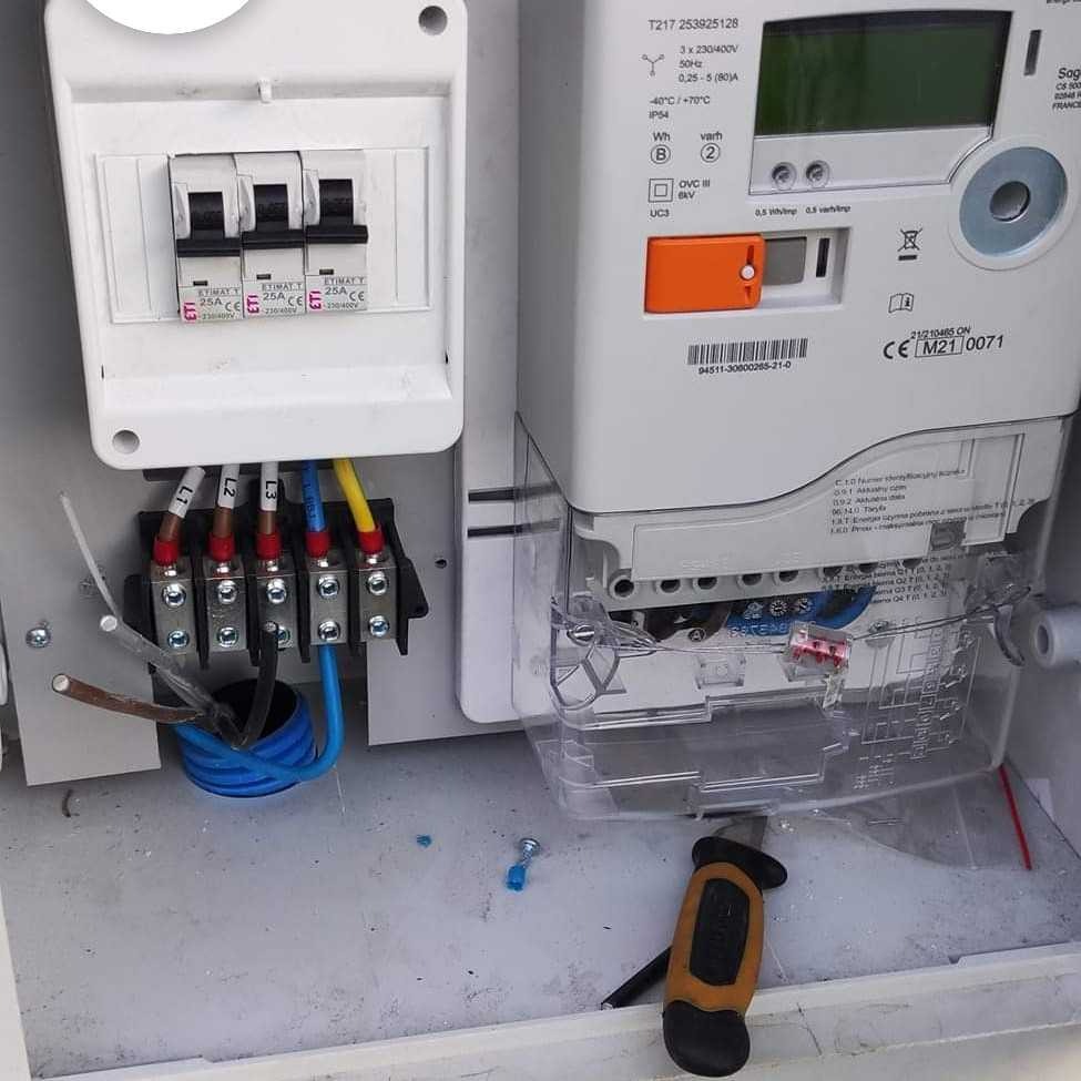 Podłączenie przewodów L1, L2, L3 do listwy zaciskowej w skrzynce z bezpiecznikami i licznikiem energii elektrycznej podczas prac w Bralin.