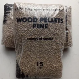 Trzy przezroczyste worki wypełnione peletem drzewnym z widocznym napisem 'WOOD PELLETS PINE' oraz wagą 15 kg, ułożone na szarej powierzchni.