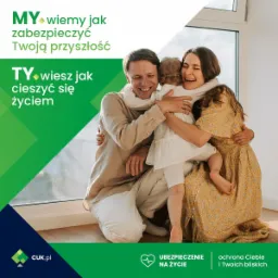 Szczęśliwa rodzina, tata, mama i dwie córki, przytulają się w jasnym wnętrzu, obok okna, z widocznym logo firmy oferującej ubezpieczenia na życie.