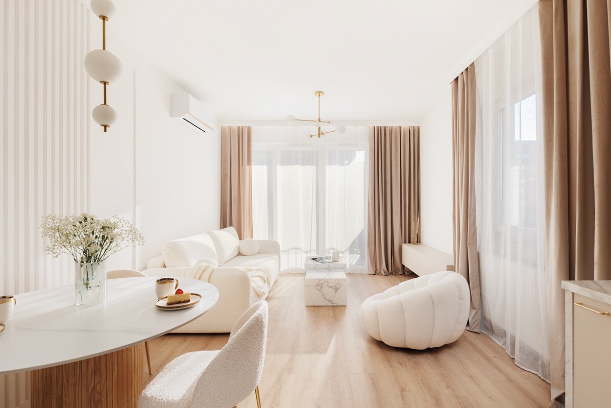 Jasne, przestronne wnętrze salonu z elementami drewna, białymi meblami, okrągłym stołem z bukietem gipsówki i marmurowym stolikiem kawowym.