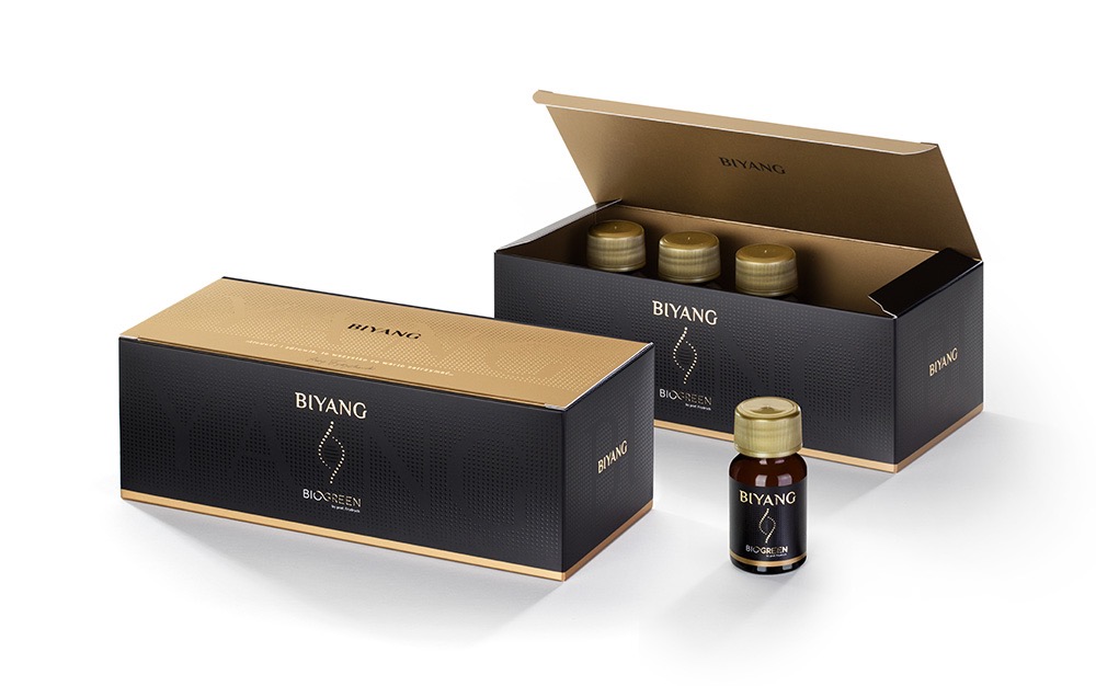 Eleganckie, czarno-złote opakowania kosmetyków Biyang Biogreen: pudełka zbiorcze i pojedyncza buteleczka na białym tle, prezentujące branding i detale produktu.