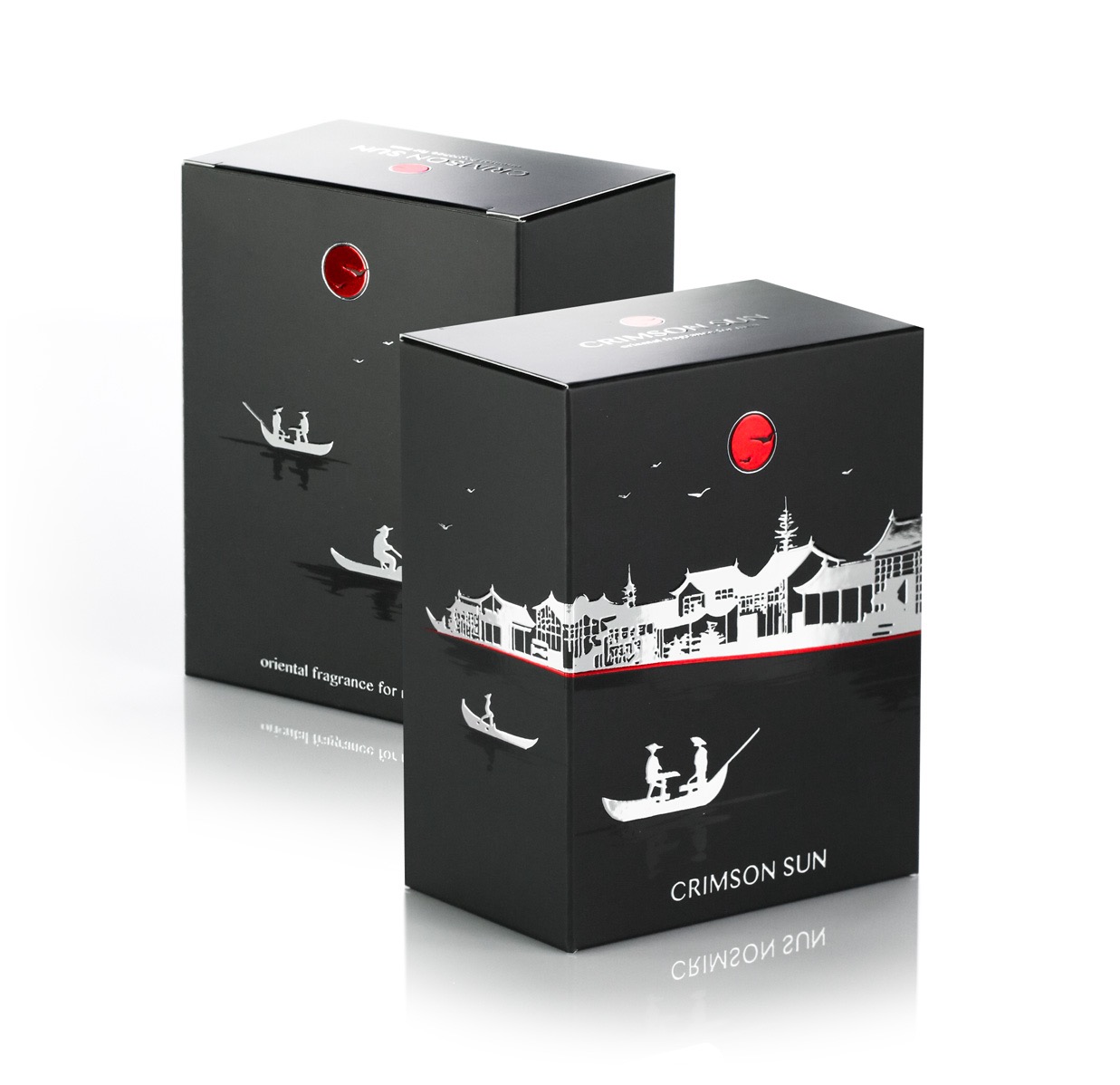 Dwa czarne, eleganckie pudełka z motywem orientalnym: gondole, budynki i czerwone słońce. Napis 'Crimson Sun' i odbicie na białym tle.