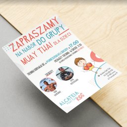 Adrian Wiczyński - Ulotka reklamowa z zaproszeniem na nabór do grupy Muay Thai dla dzieci, z informacjami o trenerach, terminach treningów i logiem klubu, leżąca na drewnianym podłożu.