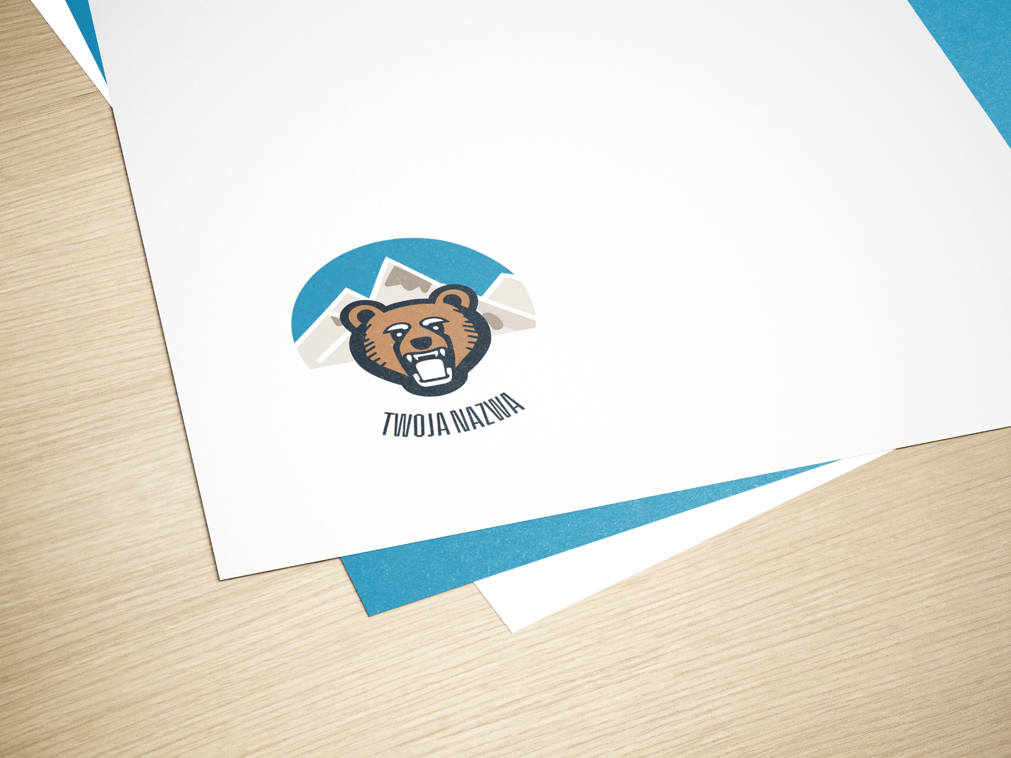 Stos arkuszy papieru z nadrukowanym logo firmy przedstawiającym niedźwiedzia na tle gór i hasłem 'Twoja Nazwa', leżący na drewnianym biurku.