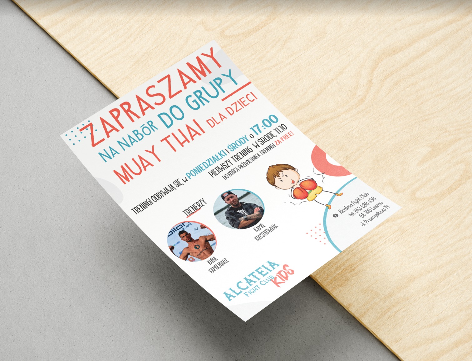 Ulotka reklamowa z zaproszeniem na nabór do grupy Muay Thai dla dzieci, z informacjami o trenerach, terminach treningów i logiem klubu, leżąca na drewnianym podłożu.