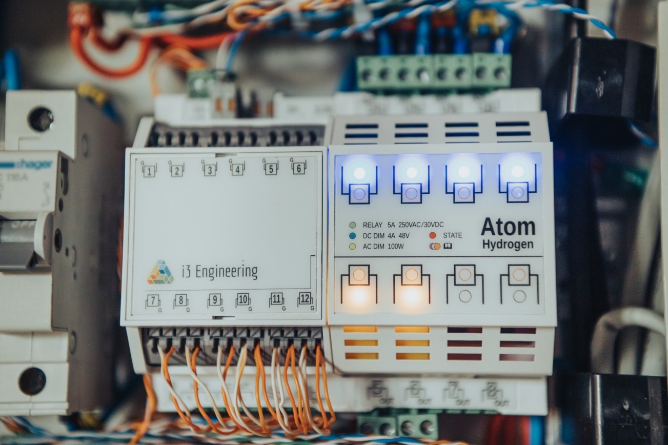 Panel sterowania z podświetlanymi diodami, widoczne przewody i oznaczenia producenta i3 Engineering oraz Atom Hydrogen.