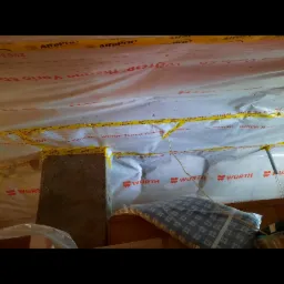 Izolacja poddasza folią Wütop Thermo Vario SD z taśmą AlfaPro, widoczny fragment komina w Słupcy.