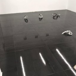 AMserwis24 - Lśniąca, świeżo umyta podłoga z ciemnych płytek w pustym pomieszczeniu biurowym, widoczne kable i mop na podłodze, ślady po wodzie.