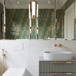 Daria Horbova Interior Architect - Nowoczesna łazienka z zielonymi, błyszczącymi kafelkami, białymi sanitariatami i umywalką nablatową na szarej szafce z złotymi uchwytami, oświetlona wiszącymi lampami z elementami złota.