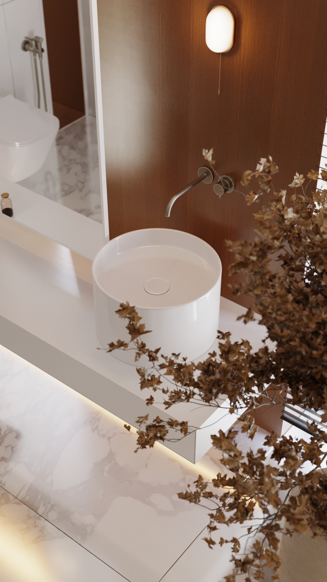 Minimalistyczna łazienka z okrągłą, białą umywalką nablatową, srebrną armaturą, oświetleniem ściennym i dekoracyjną suchą gałęzią na marmurowej podłodze.