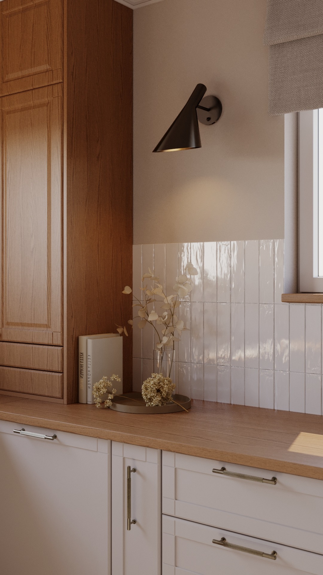 Jasna kuchnia z drewnianymi szafkami, białymi płytkami na ścianie, czarnym kinkietem i suszonymi kwiatami w wazonie na blacie.