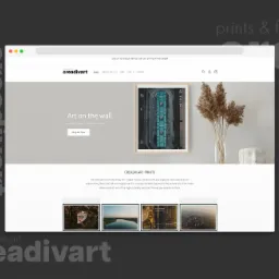 Ekran komputera prezentujący stronę internetową creadivart.com z ofertą druku artystycznego, widoczna grafika w ramie, wazon z trawami i dekoracyjna głowa.