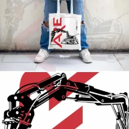 Osoba trzyma białą torbę z nadrukiem grafiki przedstawiającej koparkę w kolorach czarnym i czerwonym, widoczne nogi w podartych jeansach i białe buty sportowe, tło stanowi ściana z rozmytym szkicem...