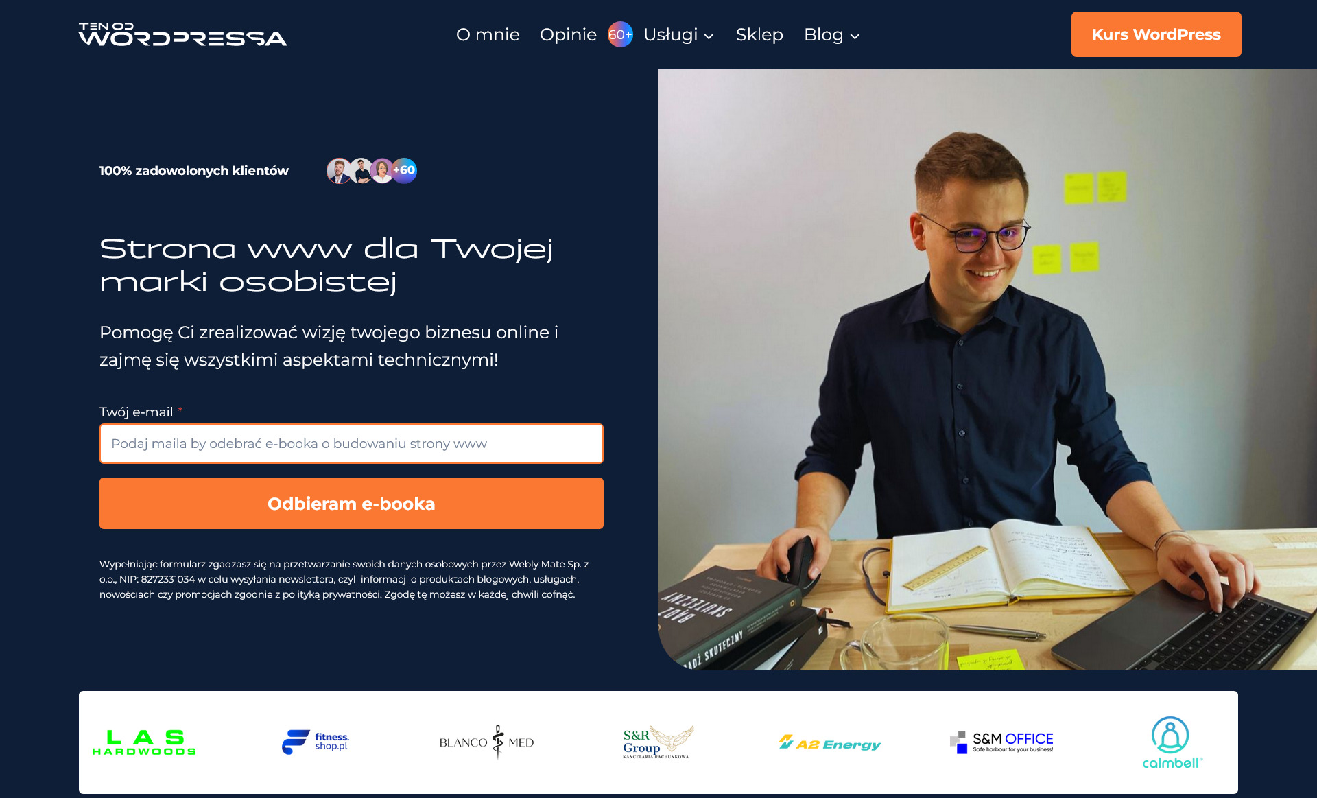 Uśmiechnięty mężczyzna w okularach, pracujący nad stroną internetową, widoczny ekran komputera, notatnik, książka 'Bądź skuteczny', kartki samoprzylepne i logo 'Ten od WordPressa' w tle.