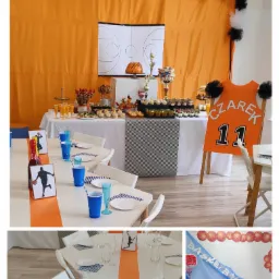 Dekoracja sali na przyjęcie urodzinowe w tematyce koszykówki: pomarańczowe tło z dekoracjami z tiulu, stół z przekąskami, tort w kształcie piłki do kosza, trofea, tabliczki z sylwetkami koszykarzy,...