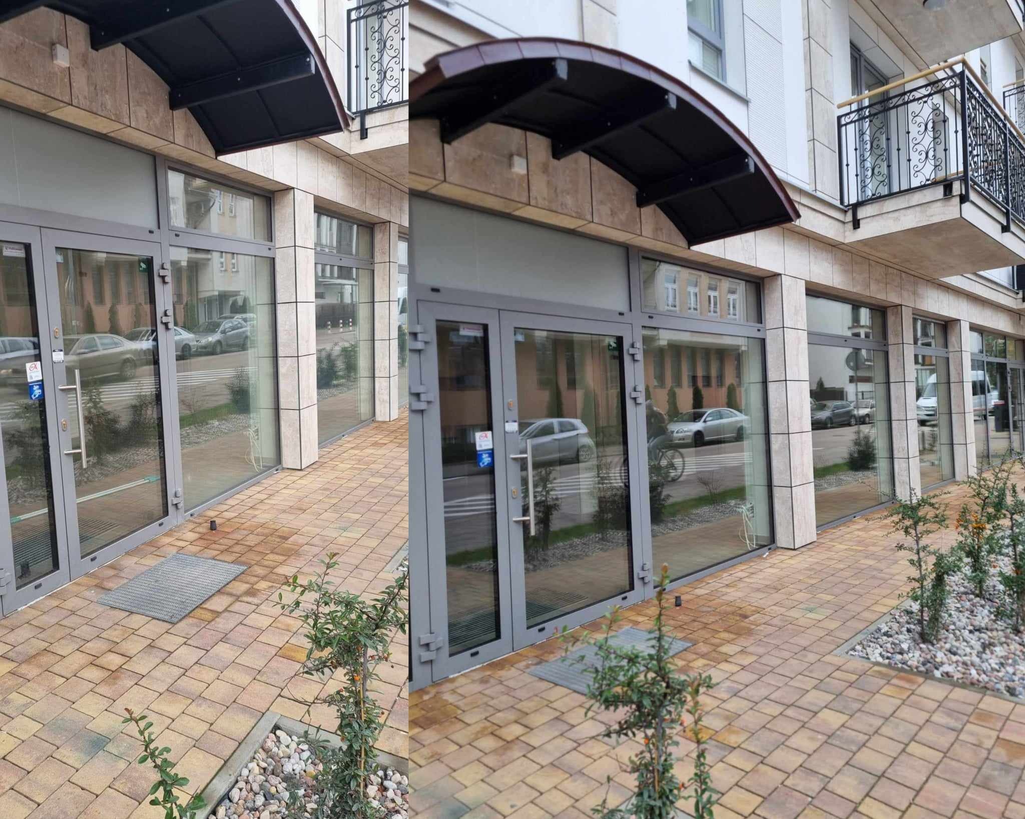 Fasada budynku biurowego z dużymi, szklanymi oknami i drzwiami wejściowymi, widoczna z zewnątrz na tle ulicy i chodnika wyłożonego kostką brukową.