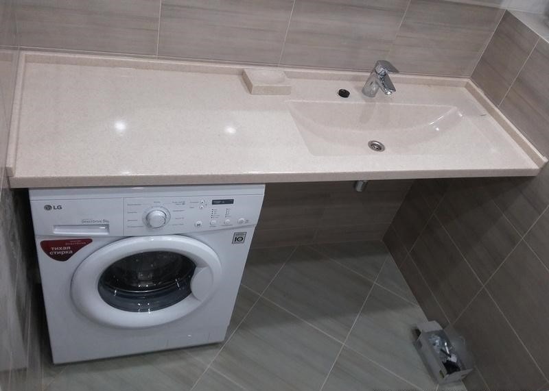 Łazienka z blatem z umywalką i pralką LG pod spodem, szara glazura na ścianach i podłodze.