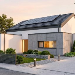 ATO-ARCHITEKTURA - Nowoczesny dom jednorodzinny z panelami słonecznymi na dachu, szarą elewacją i garażem, otoczony zielenią i ogrodzeniem. Widok z poziomu ulicy, ciepłe oświetlenie.