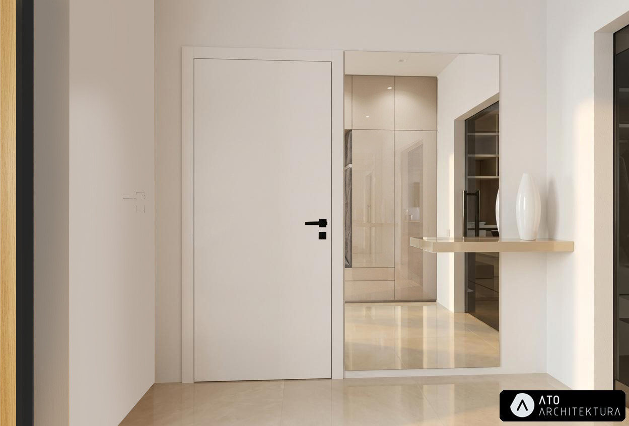 Minimalistyczny przedpokój z białą szafą, drzwiami i lustrem. Beżowa podłoga i półka z wazonem. Widoczne logo firmy projektowej w prawym dolnym rogu.