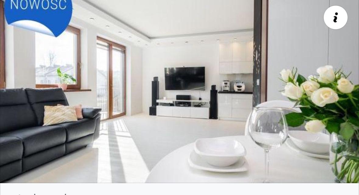 Jasne, przestronne wnętrze z czarną skórzaną sofą, białymi meblami i bukietem białych róż na okrągłym stole. Widoczne duże okna balkonowe i sprzęt RTV.